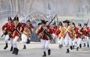 soldiers running in the park with rifles in uniform for Patriots Day